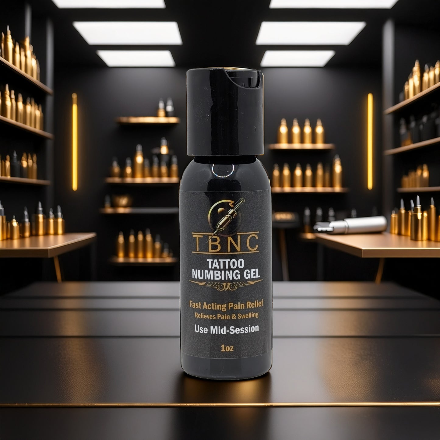 A bottle of TBNC - The Best Numbing Cream Tattoo Numbing Gel - Mid Session, known for fast pain relief, sits in focus on a dark reflective surface. Gold bottles and a tattoo machine appear in the well-lit, modern studio background.