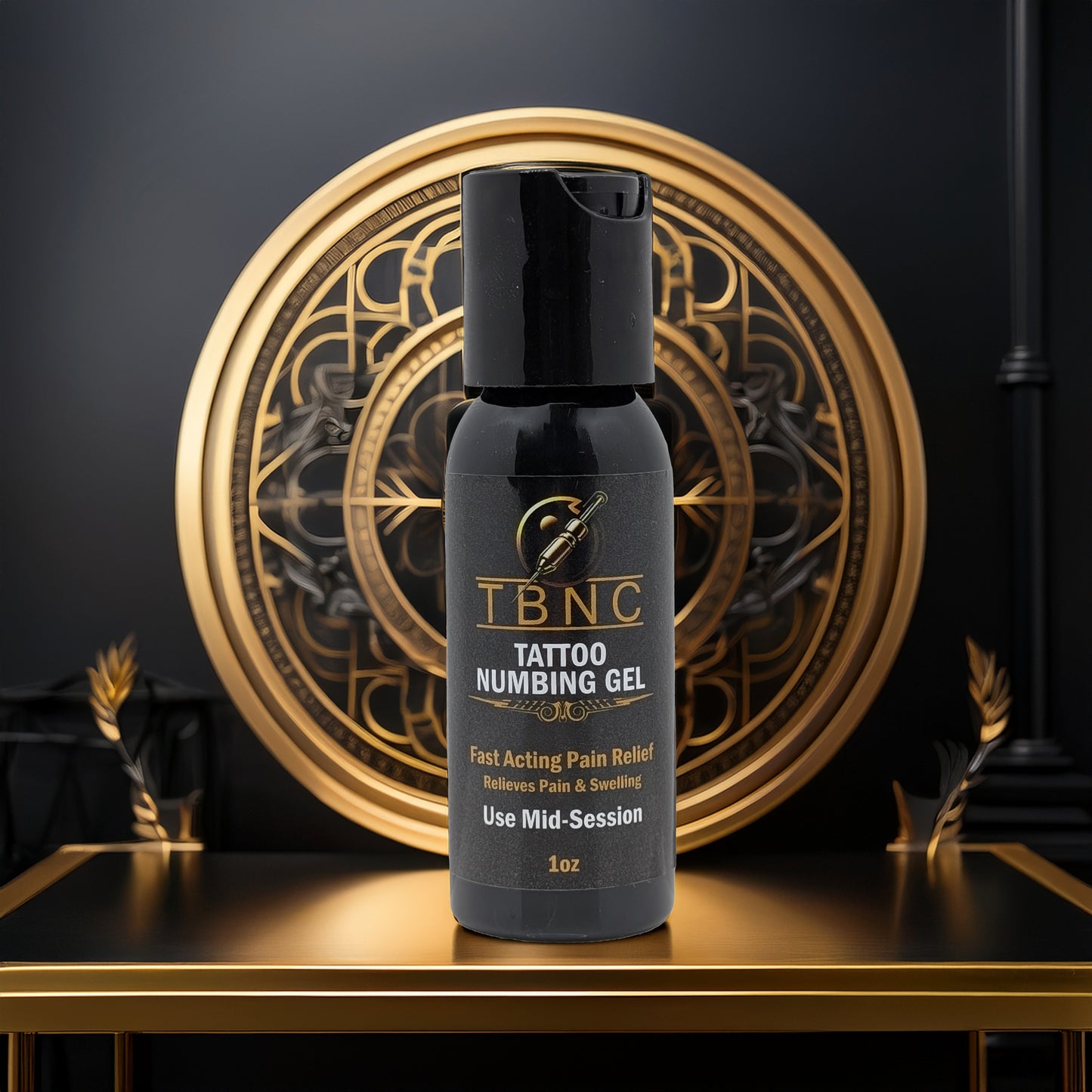 A black bottle of TBNC - The Best Numbing Cream's Tattoo Numbing Gel - Mid Session sits on a black and gold pedestal, with an ornate circular gold design behind. The label highlights Fast Pain Relief and mid-session tattoo numbing.