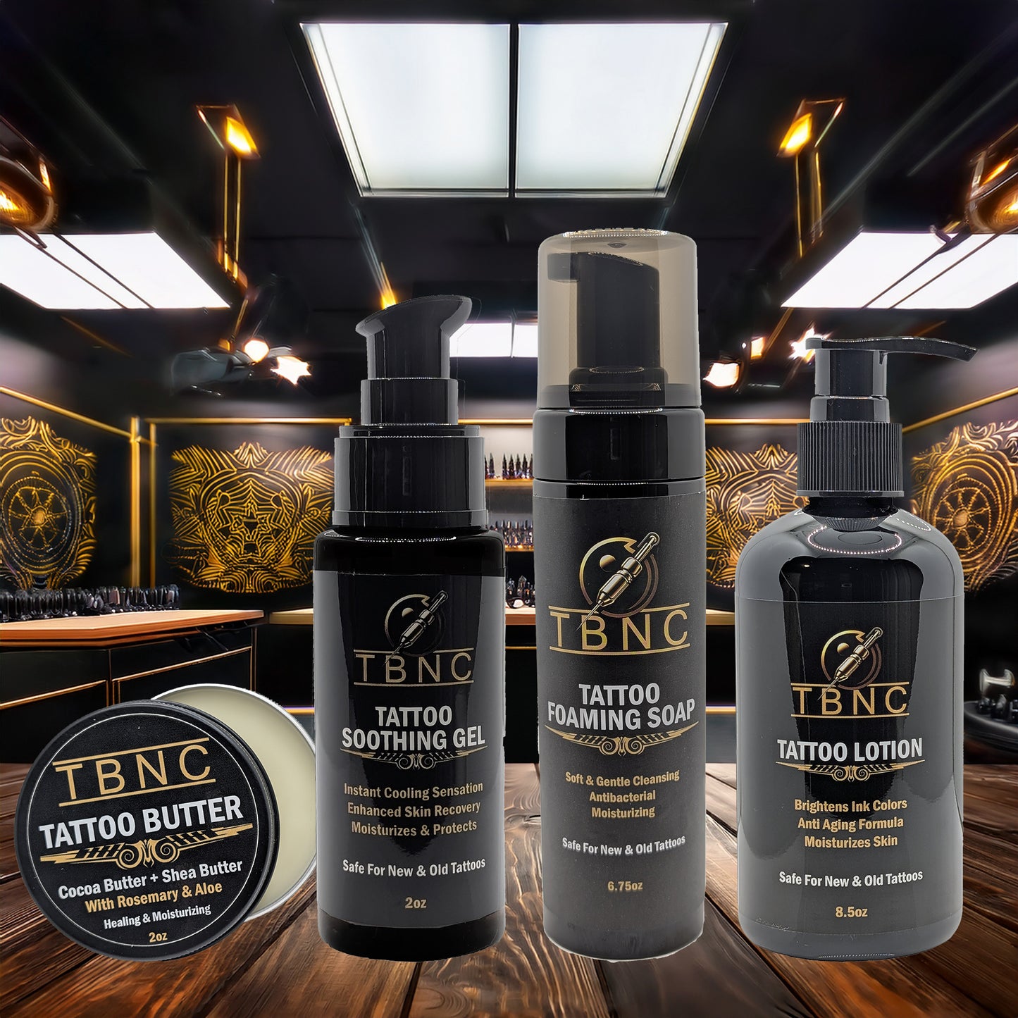 The TBNC – The Best Numbing Cream Tattoo Aftercare Bundle is displayed on a wooden surface in a tattoo studio, offering a complete aftercare solution with products all labeled under the TBNC brand.