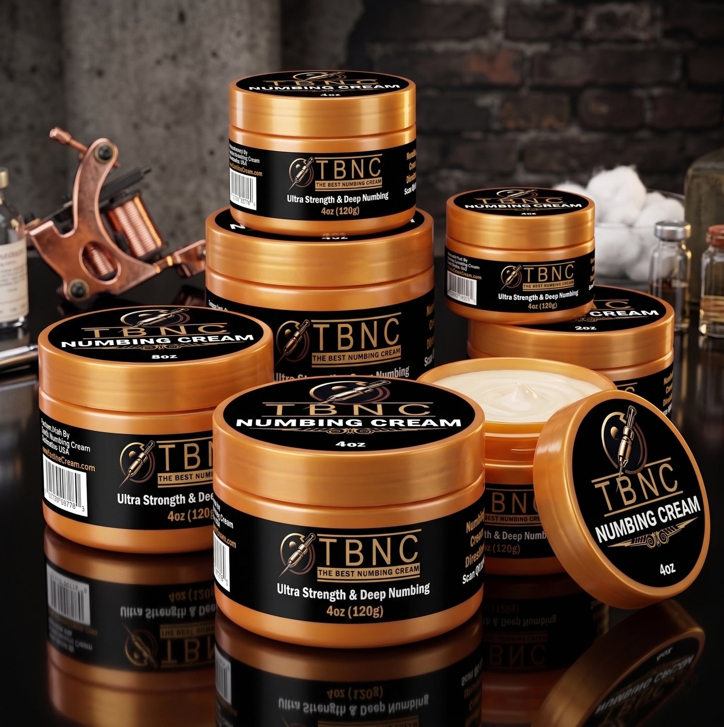 Round containers of the top-selling Tattoo Numbing Cream ULTRA, labeled "Ultra Strength & Deep Numbing," stacked on a dim table; one large jar open to show potent cream inside.