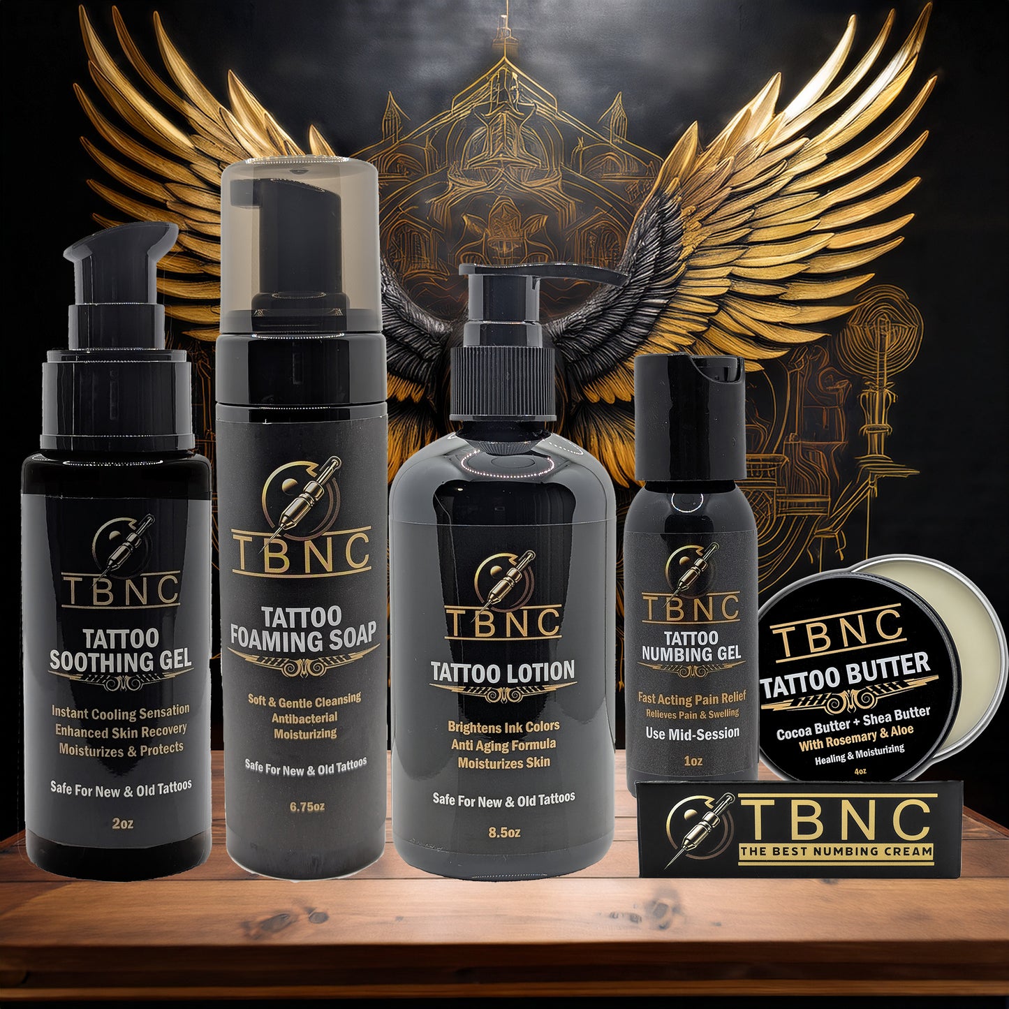 The TBNC - The Best Numbing Cream Tattoo Numbing & Aftercare Bundle is displayed before a gold winged emblem on a dark background, emphasizing its premium brand image.
