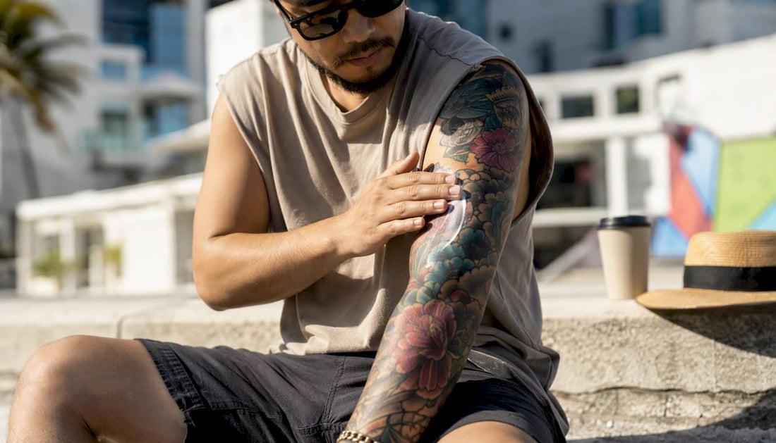 Person applying sunscreen on healed arm tattoo