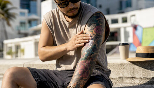 Person applying sunscreen on healed arm tattoo
