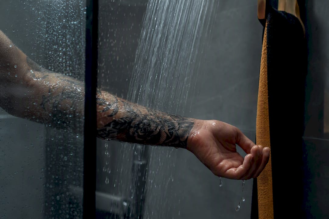 Fresh tattoo under gentle shower water