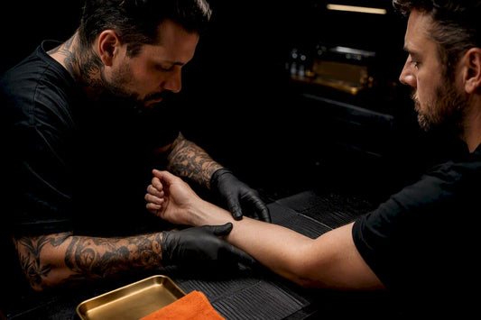 Artist checking client’s forearm before tattooing
