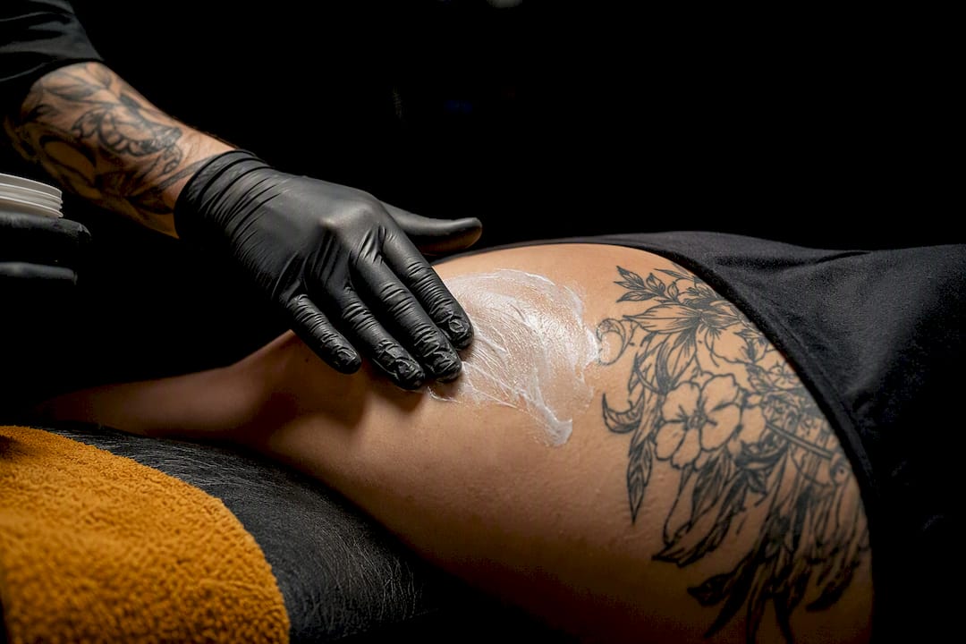 Artist applying numbing cream before tattooing