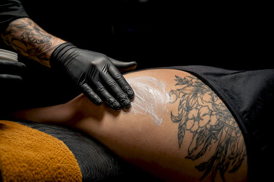 Artist applying numbing cream before tattooing
