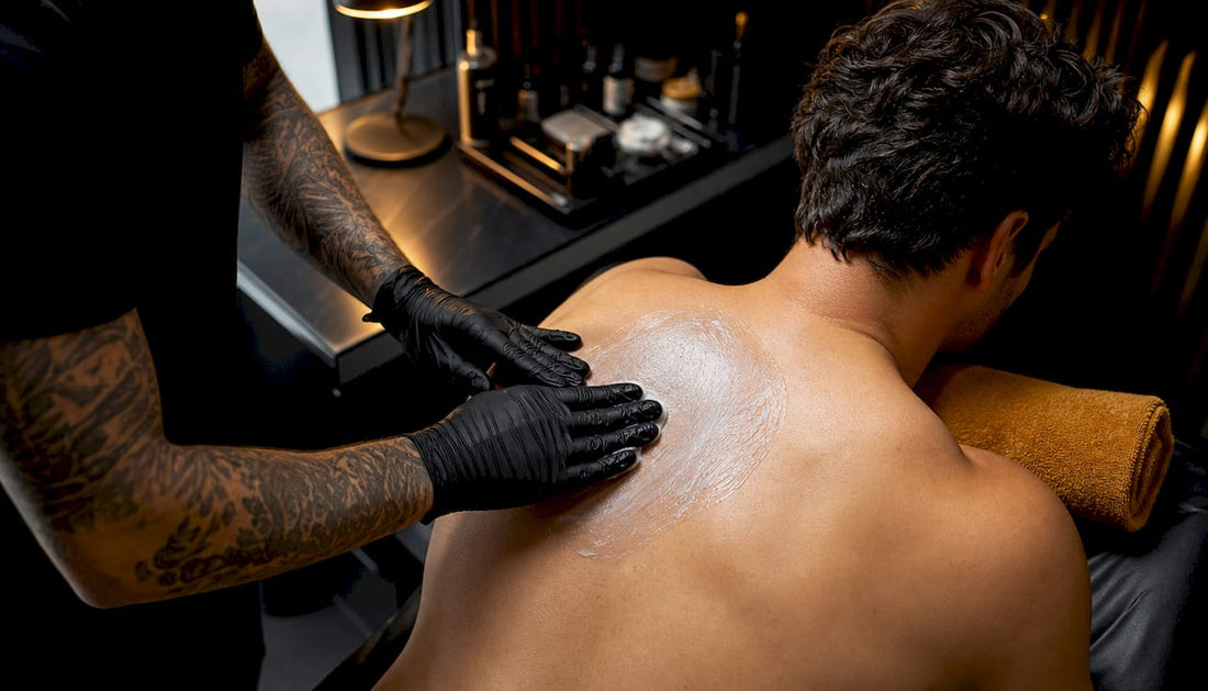 Artist applying numbing cream to upper back