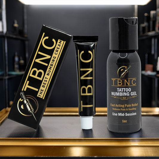 The TBNC - The Best Numbing Cream Tattoo Numbing Bundle is displayed on a black surface, with shelves and tattoo supplies blurred in the background, highlighting the perfect set for effective tattoo numbing.