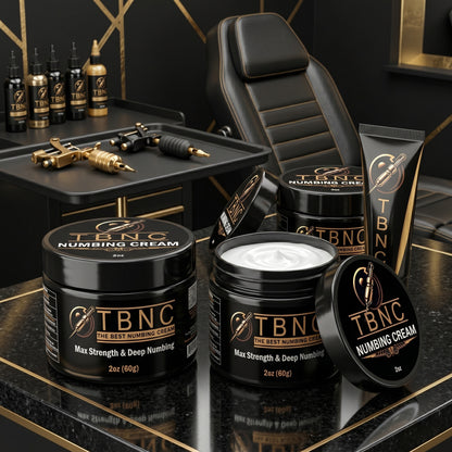 TBNC Tattoo Numbing Cream MAX jars and tubes, best sellers, are showcased on a luxe black and gold table in a modern studio.