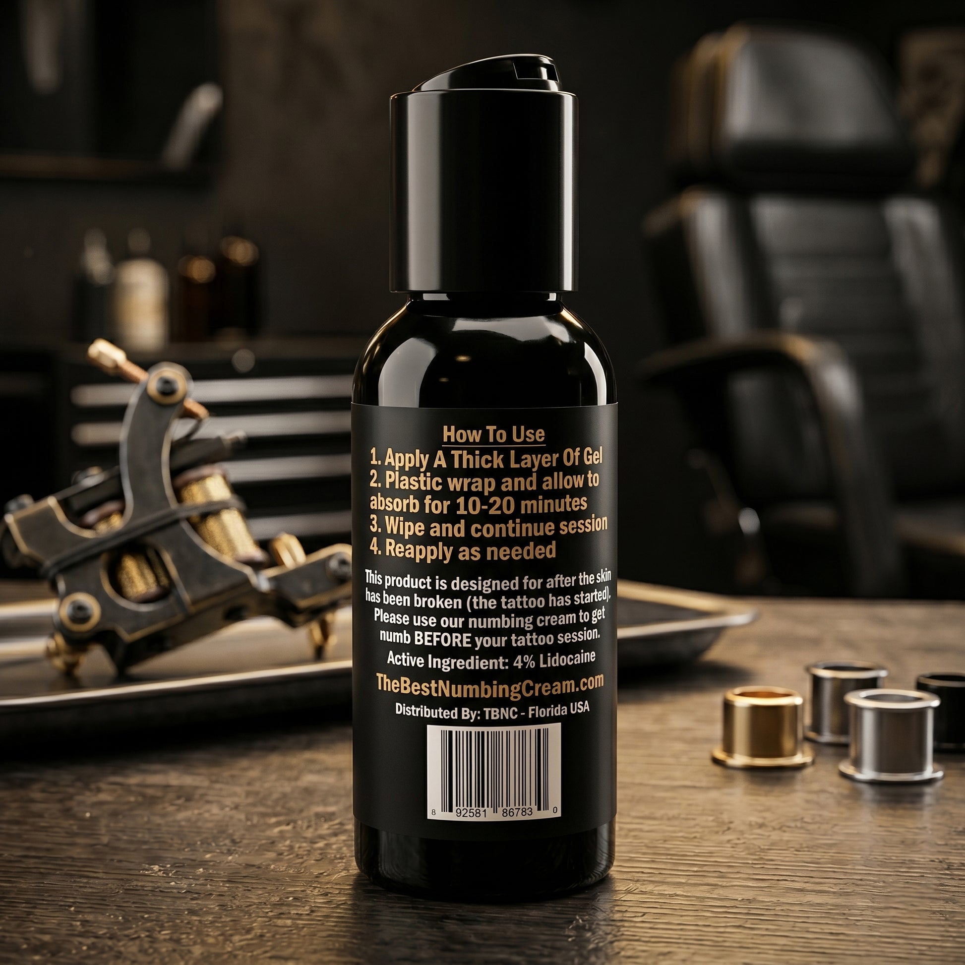 A premium TBNC Tattoo Numbing Gel bottle with instructions sits by a tattoo machine and ink caps, trusted for rapid pain relief.