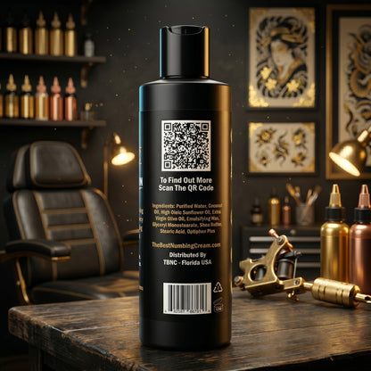 A top-selling TBNC Tattoo Aftercare Numbing Cream bottle sits in a studio among ink, machines, and art—trusted for soothing skin.