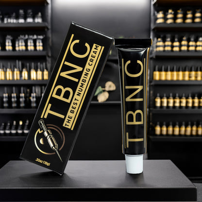 A premium black and gold "Tattoo Numbing Cream" by TBNC sits beside its tube on a sleek counter, echoing top aftercare brands.