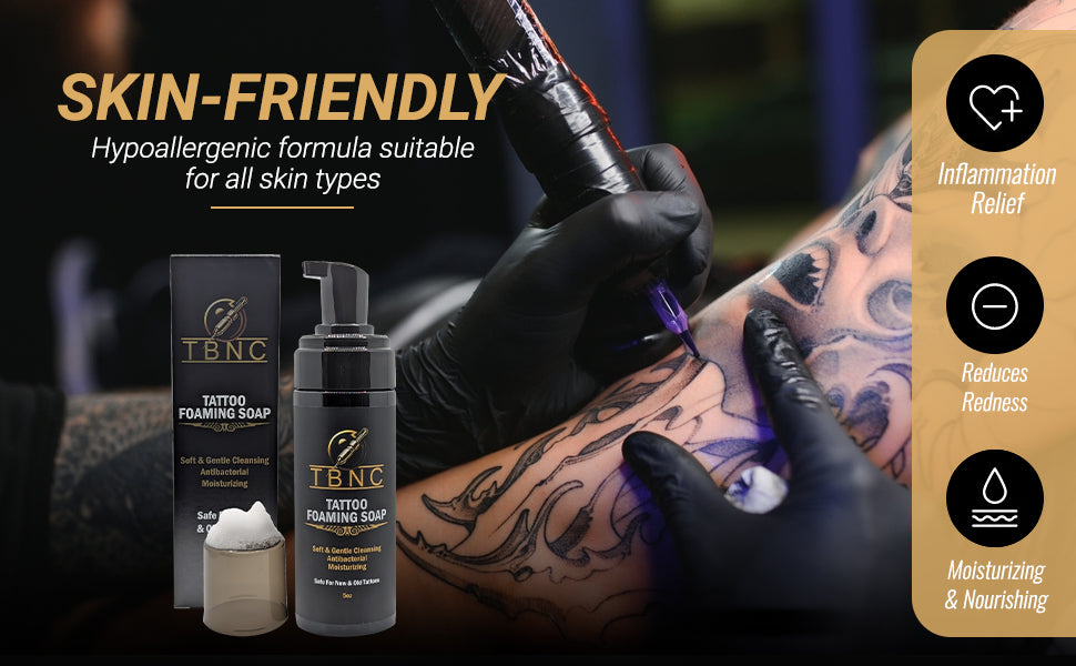 A tattoo artist works on a client’s arm as TBNC - The Best Numbing Cream Tattoo Foaming Soap sits in the foreground—a skin-friendly, hypoallergenic antibacterial soap that relieves inflammation, reduces redness, and moisturizes.