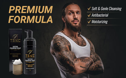 A bearded, tattooed man stands confidently with arms crossed beside TBNC - The Best Numbing Cream Tattoo Foaming Soap. Text highlights: "Premium Formula," "Soft & Gentle Cleansing," "Antibacterial tattoo soap," and "Moisturizing.