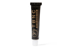 A black tube of "The Best Numbing Cream - TBNC" with gold text and a white cap. The tube features the TBNC logo and the tagline "The Best Numbing Cream" written vertically alongside an illustration of a person. Perfect as an advanced tattoo numbing cream for painless tattoos.