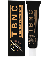 A black tube labeled "The Best Numbing Cream - TBNC" sits next to its matching box, which displays the same text and an image of a syringe. Designed for painless tattoos, the sleek box and tube feature gold and silver accents, highlighting the cream's advanced numbing properties.